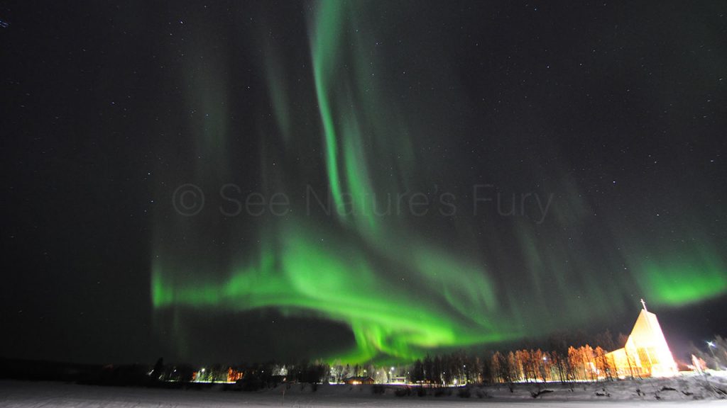 The northern lights dance above a church in a small Finnish village. This was shot during a storm chasing, weather and photography tour.
