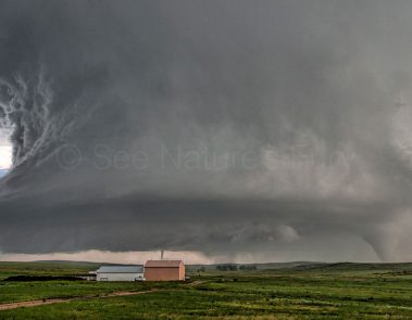 An enormous supercell with large cone tornado and satellite tornado over open farmland in Colorado. This was shot during a storm chasing, weather and photography tour.